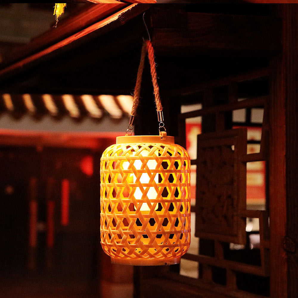 Solar rattan lantern in khaki styled among potted plants on a patio