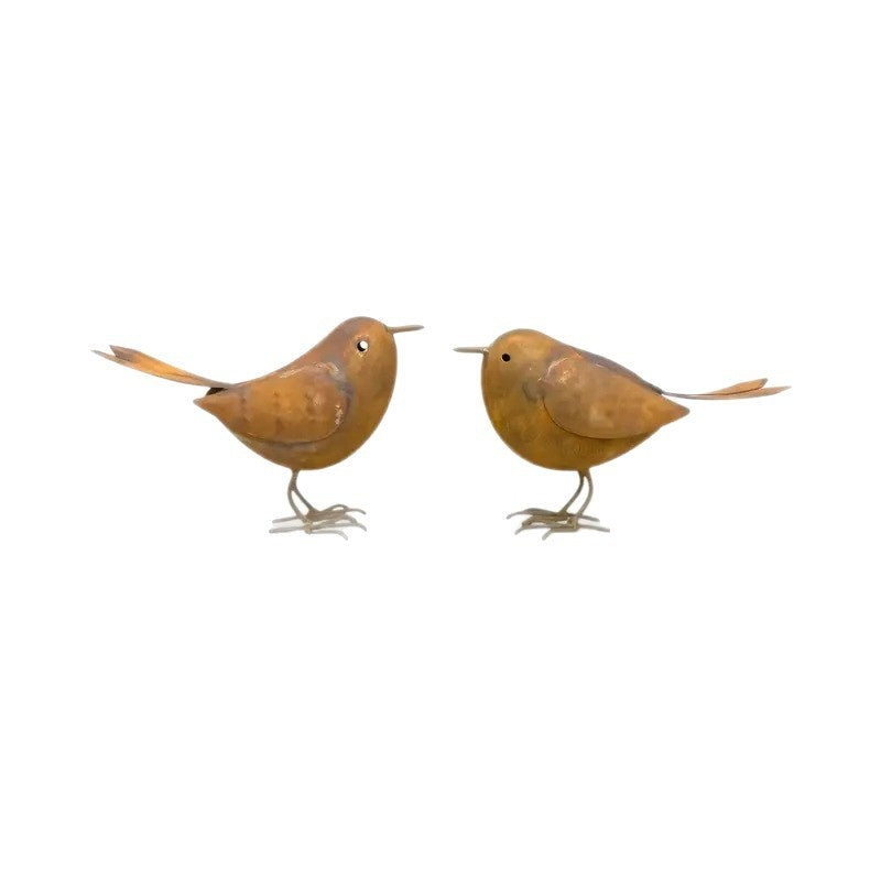 Iron bird garden decoration styled in a raised garden bed with herbs and flowers
