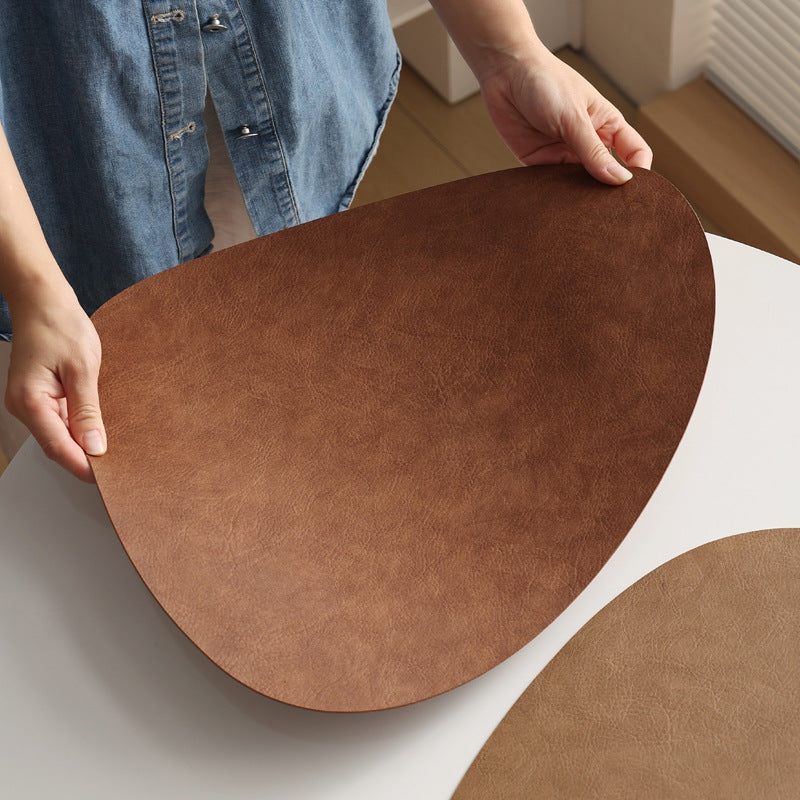 Tuscany leather placemat styled with a ceramic bowl and cutlery on a linen tablecloth