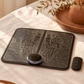 Slim EMS foot massager mat with wireless remote placed on cream linen fabric in soft natural light.