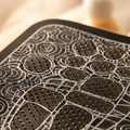 Close-up of the textured electrode surface of the EMS foot massager mat showing raised massage nodes and conductive pads.